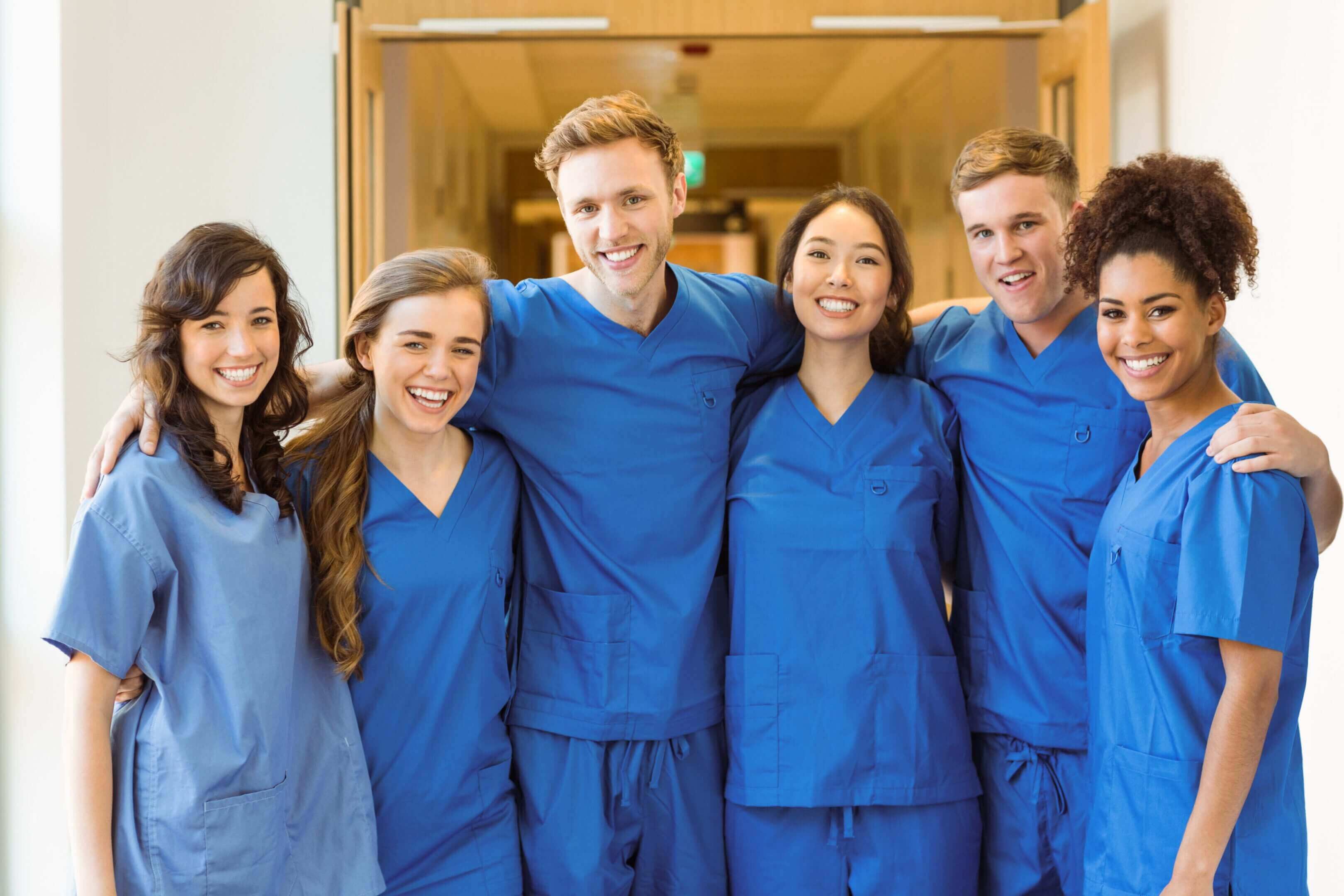 Group of smiling medical professionals in scrubs.