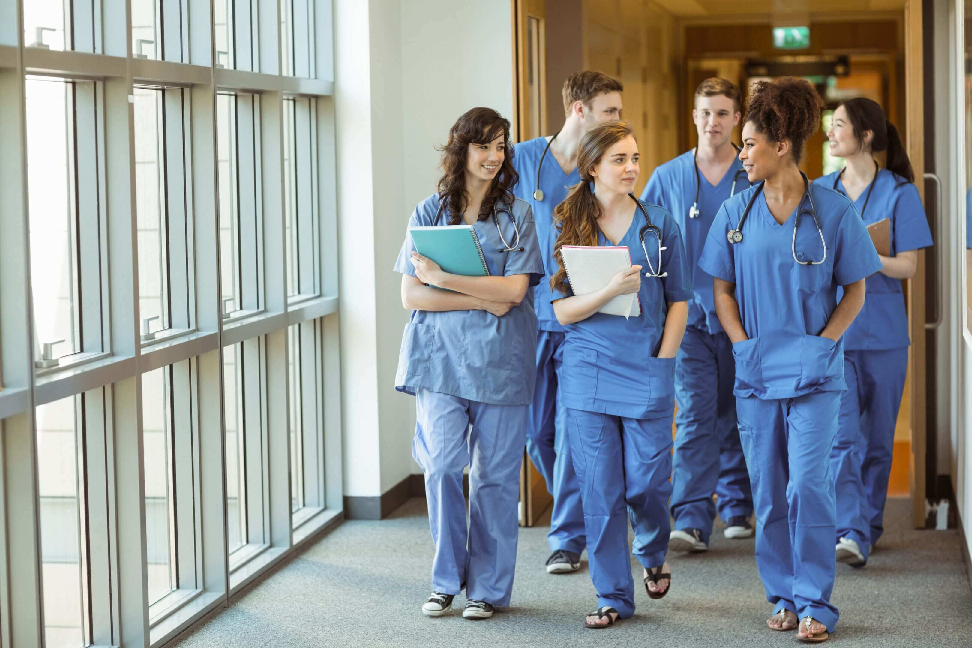 Medical students walking in hospital corridor.