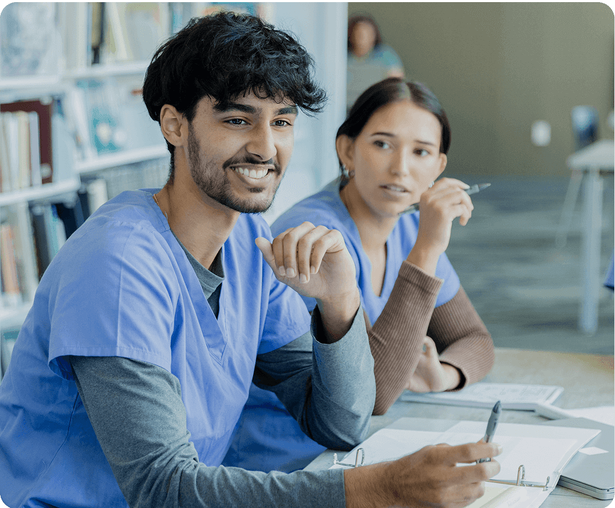 Students in blue scrubs studying together.